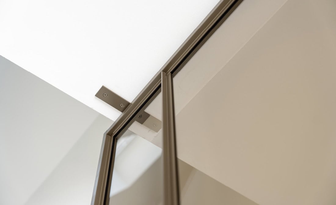 Strakke stalen deurmontage met glazen panelen, maatwerk en moderne afwerking voor een strakke en functionele uitstraling.