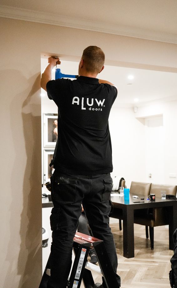 Robuuste stalen deur met op maat gemaakte wandinstallatie door Aluwdoors.