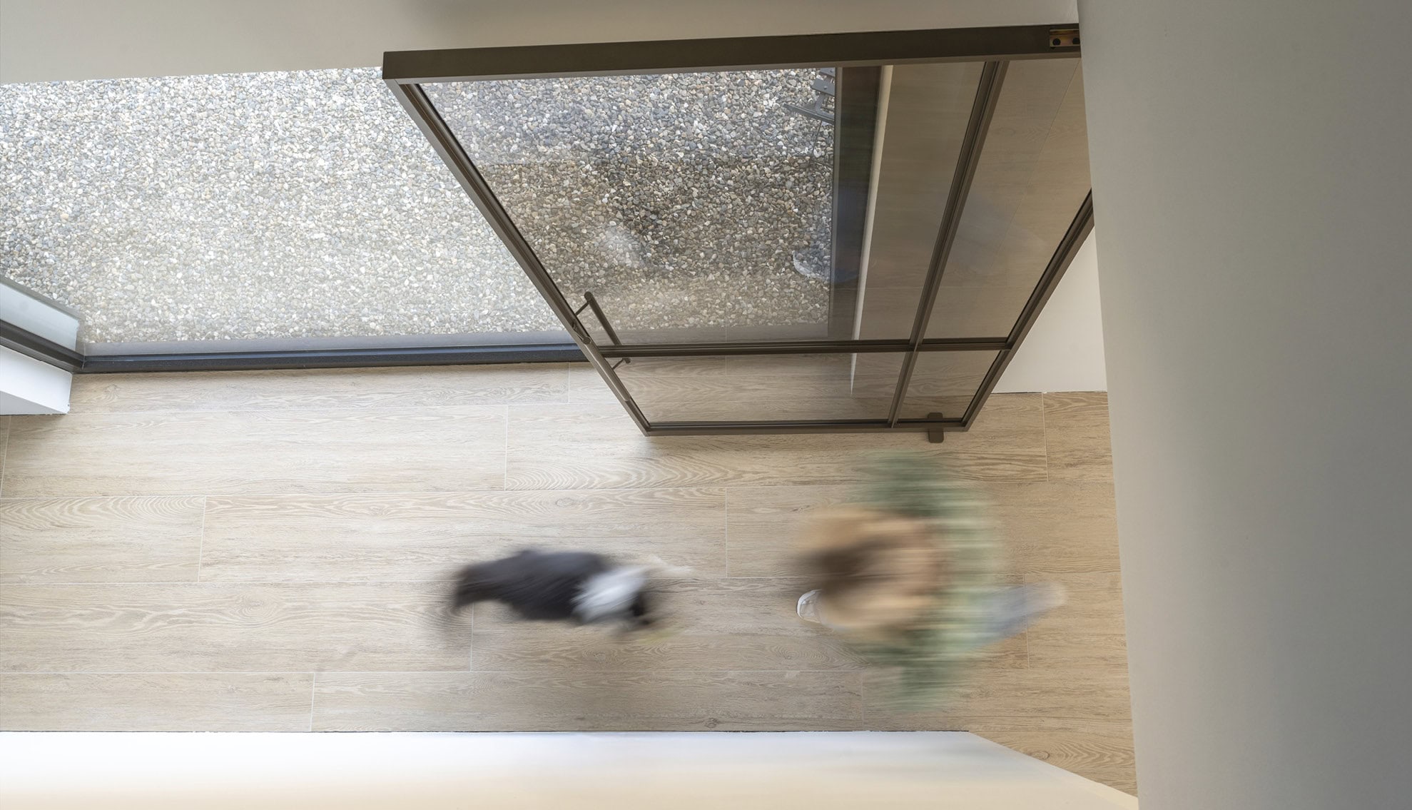 Lightweight steel sliding door with glass in black frame, modern interior and exterior space, seamless finish and clean lines, custom-made by Aluwdoors.