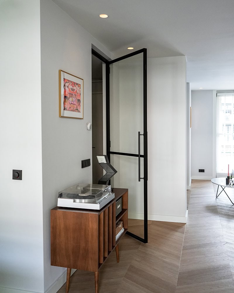 Steel glass interior door with black frame in modern interior, custom-made for a clean and durable partition.