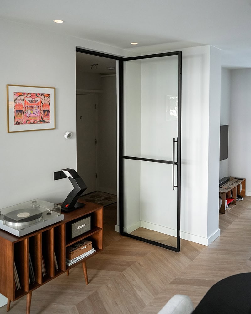 Sleek steel sliding door with black metal frame and glass, perfect for modern interior separation.
