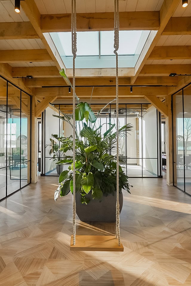 Hoogwaardige stalen deur en wand op maat in modern interieur, natuurlijke houten frame, glaswanden en groene planten, stijlvolle en functionele ruimte inrichting.