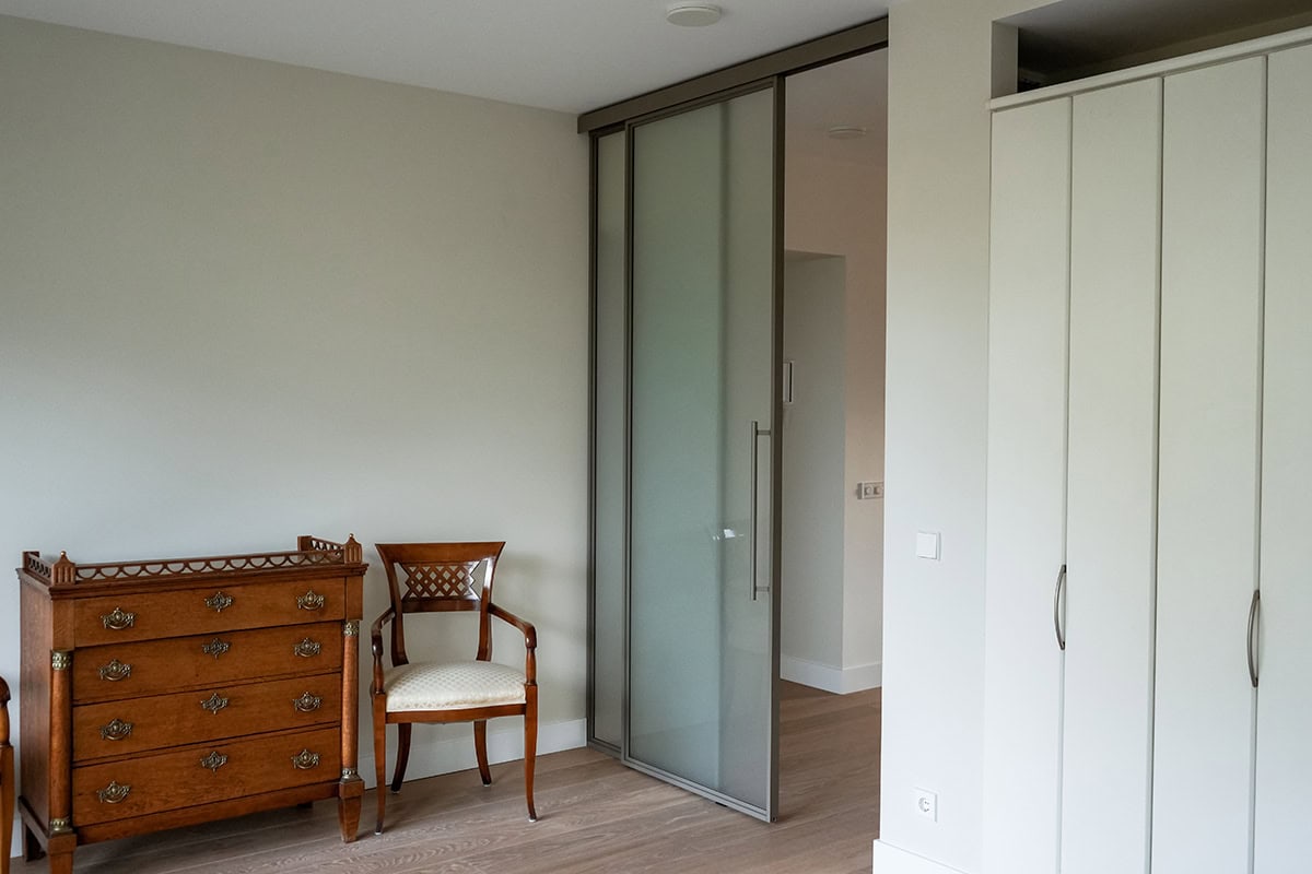Steel sliding door with side panel between two walls.