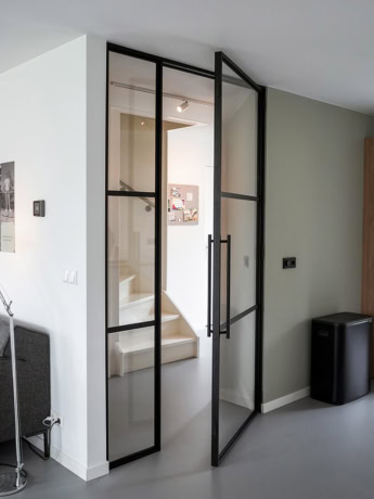Rolgordijn glazen deur met zwart metalen frame in modern interieur.