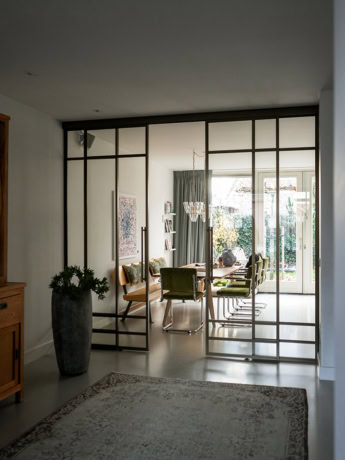 Moderne stalen scheidingswand met glazen panelen, perfect voor het creëren van een stijlvolle en open ruimte binnen een woning.