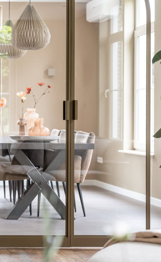 Sleek glass partition with steel frame and handles, suitable for home and office interiors, modern and functional design.