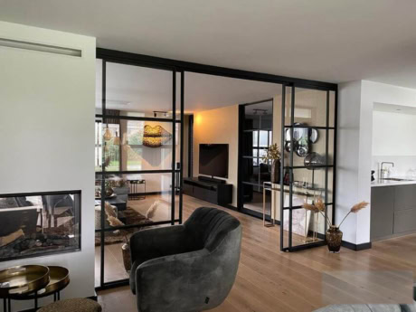 Strakke stalen schuifdeuren met glas, scheiden woonkamer en keuken, moderne interieurstijl, op maat gemaakte wanden, hoogwaardige afwerking.