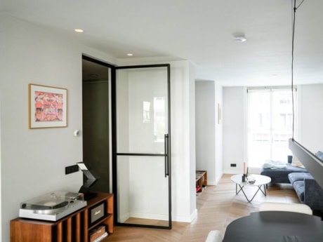 Sleek steel partition door in a modern living room, ideal for separating spaces with a minimalist design and plenty of natural light.