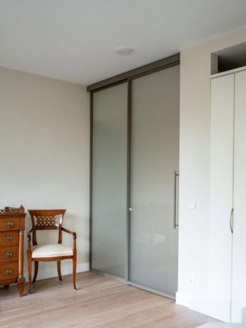 A modern steel sliding door with frosted glass in a contemporary interior, perfect for separating rooms or walk-in wardrobes, made to measure by Aluwdoors.