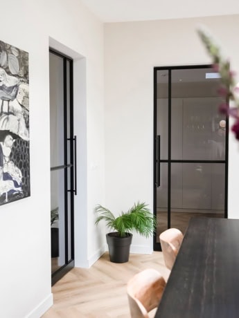 Modern stalen deur met zwart frame en glas, perfect voor afsluiten van woonruimtes, uitgevoerd op maat door Aluwdoors.
