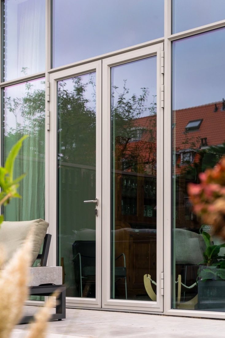 High-quality steel patio door with large glass sections and sleek aluminium finish, suitable for modern living and working environments.