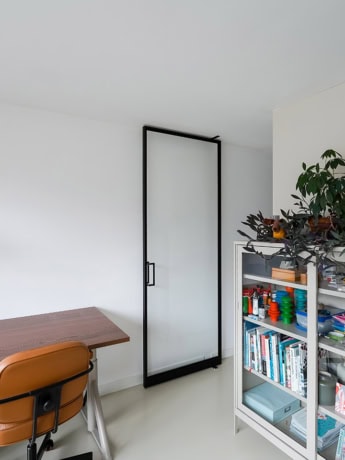 Glazen stalen schuifdeur met zwart frame in woonkamer voor een moderne look.