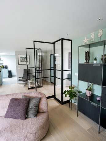 Luxe stalen scheidingswand met op maat gemaakte deuren in modern interieur.
