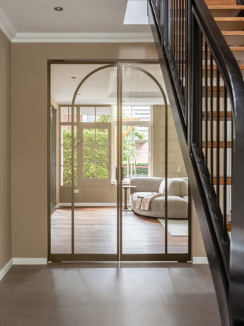 Elegante stalen schuifdeur met glazen panelen en urbane uitstraling, perfect voor een moderne woonruimte.