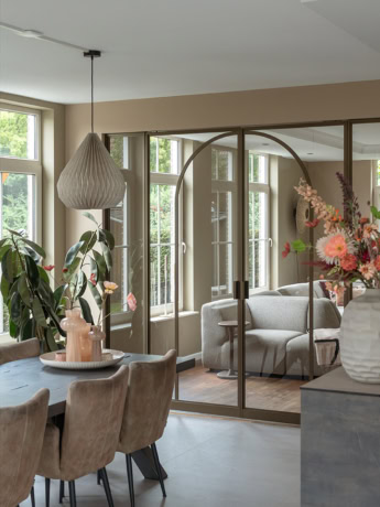 Hoogwaardige stalen scheidingswand met glazen schuifdeuren in een modern woondecor, op maat gemaakt door Aluwdoors.