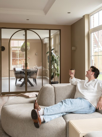 Stalen deur met glazen wand in modern interieur, scheidt woonkamer en eetkamer, op maat gemaakte deuren van Aluwdoors.
