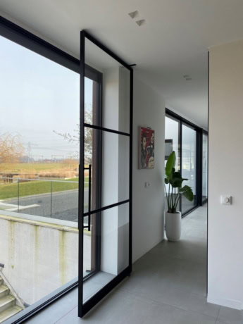 A sleek steel pivot door with large glass panels, ideal for modern homes and for creating an open-plan interior, from Aluwdoors.