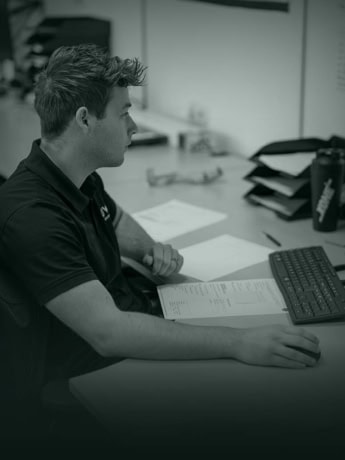 Modern man die aan een bureau werkt met documenten en computer in kantooromgeving.