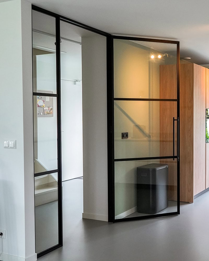 Hoogwaardige stalen deur met zwart metalen kader en glas voor moderne interieurs.