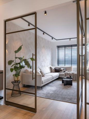 Modern stalen roomdivider met glazen panelen, zwart metalen frame en elegant interieurdesign, ideaal voor stijlvolle scheidingen in woonruimtes.