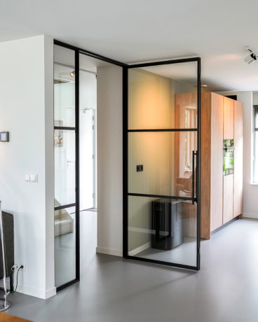 Elegante stalen en glazen scheidingswand met zwart frame voor moderne interieurafwerking.