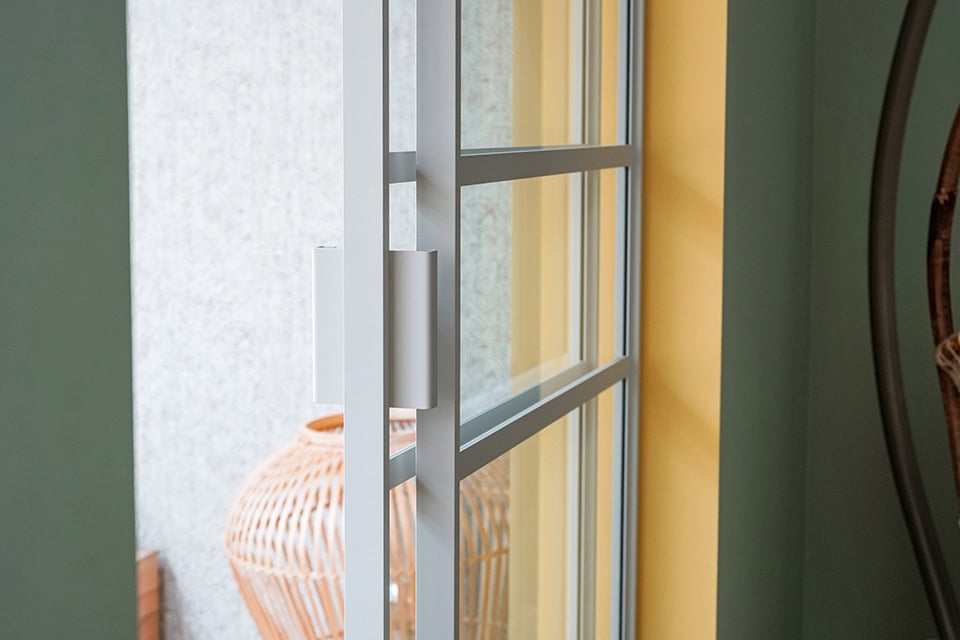 Zwarte stalen deur met glazen panelen voor een moderne en stijlvolle uitstraling.