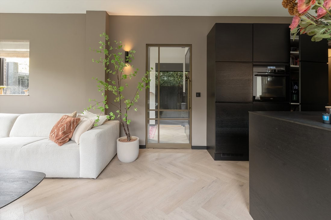 Modern steel door with glass panels in a sleek living room.