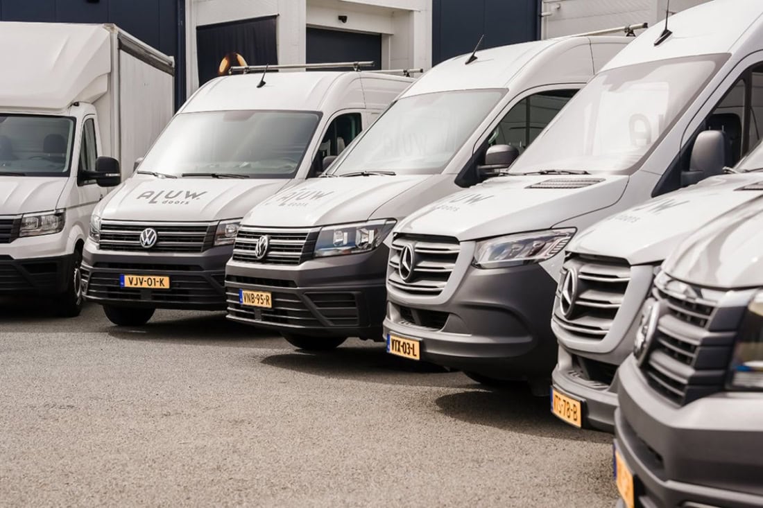 Several commercial vehicles parked in front of Aluwdoors, specialising in customised steel doors and walls.