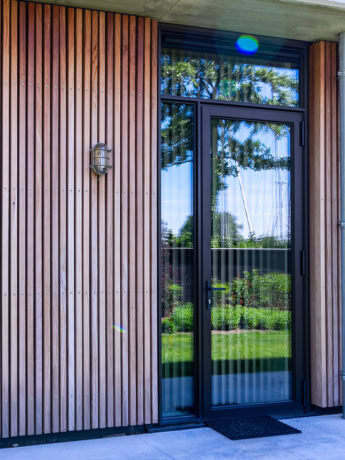 Hoogwaardige stalen voordeur met groot glas en zwart frame, modern design, op maat gemaakt, perfect voor moderne woning, duurzame stalen deuren en wanden, aluwdoors.nl.