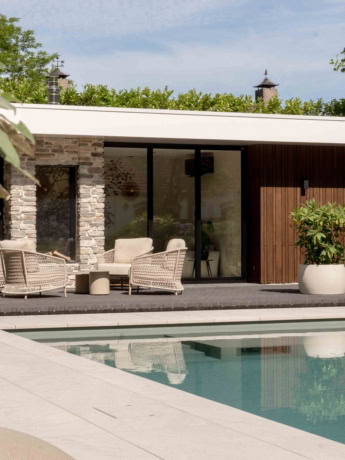 Modern home with large glass sliding doors, comfortable outdoor seating area and swimming pool, perfect for indoor-outdoor living space, bespoke steel doors and walls.