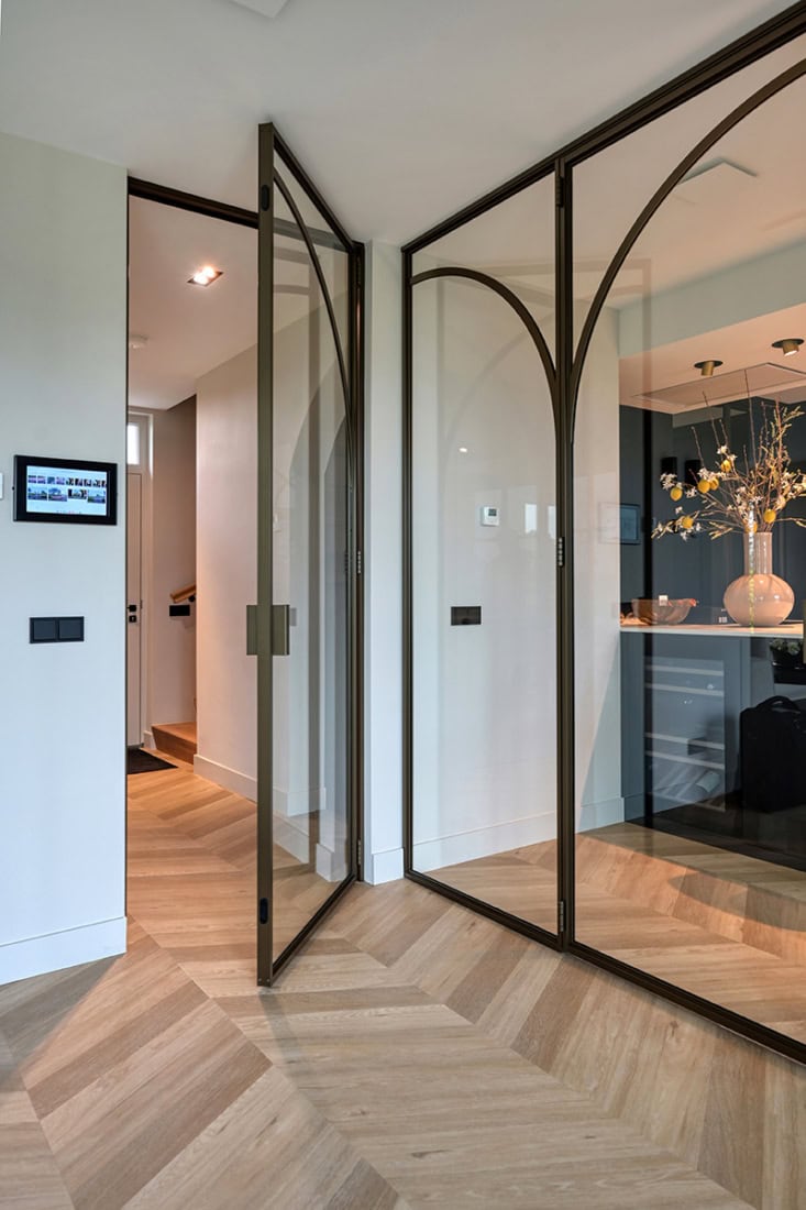 Hoogwaardige stalen glazen scheidingswand met zwarte metalen frame in modern interieur.