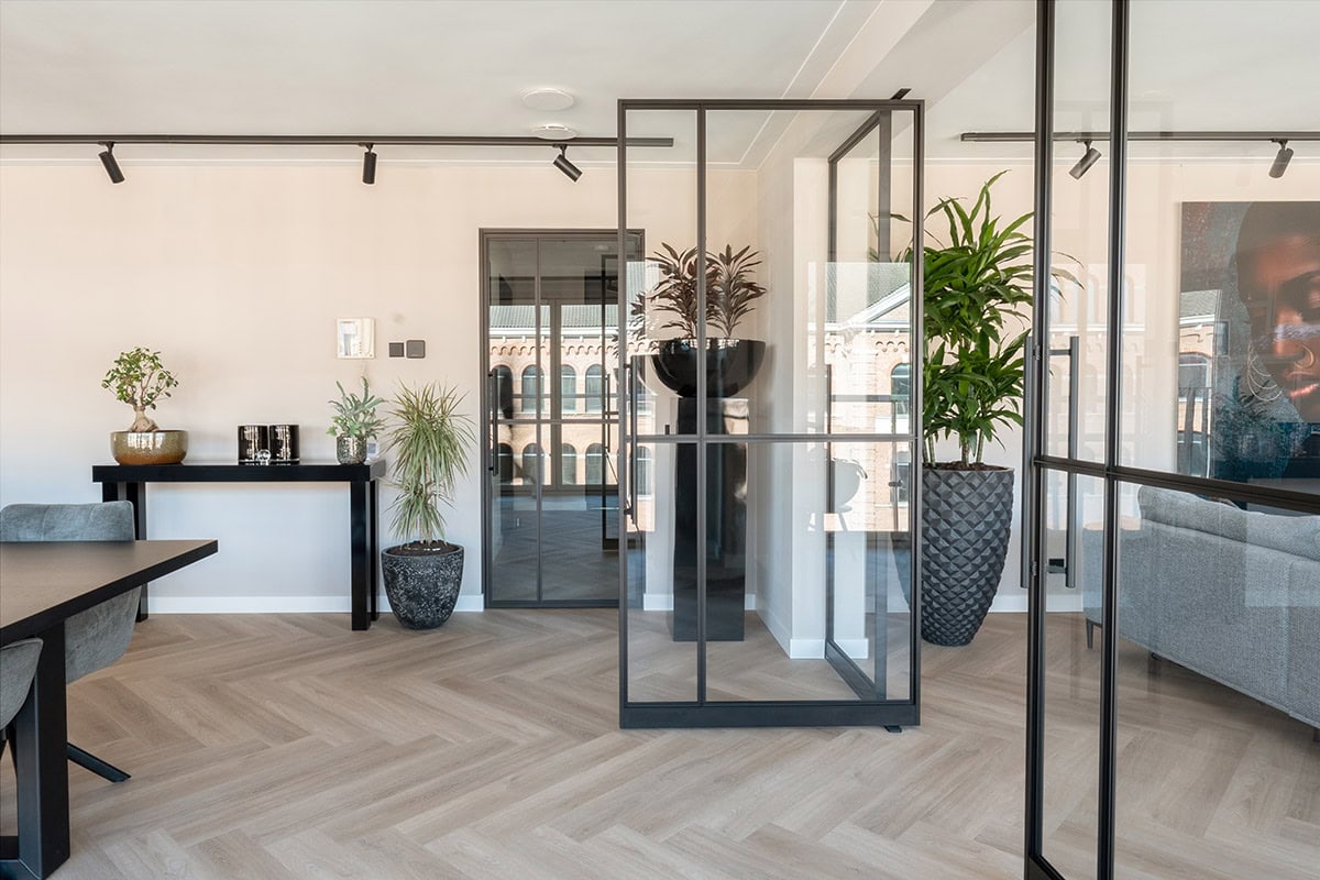Moderne stalen scheidingswanden en deuren op maat in een strak en minimalistisch interieur.