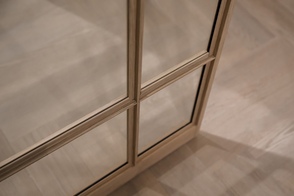 Strak stalen deur met houten kozijn en glazen panelen, maatwerk oplossingen voor elegante interieurafwerkingen, industriële looks, en duurzame kwaliteit.