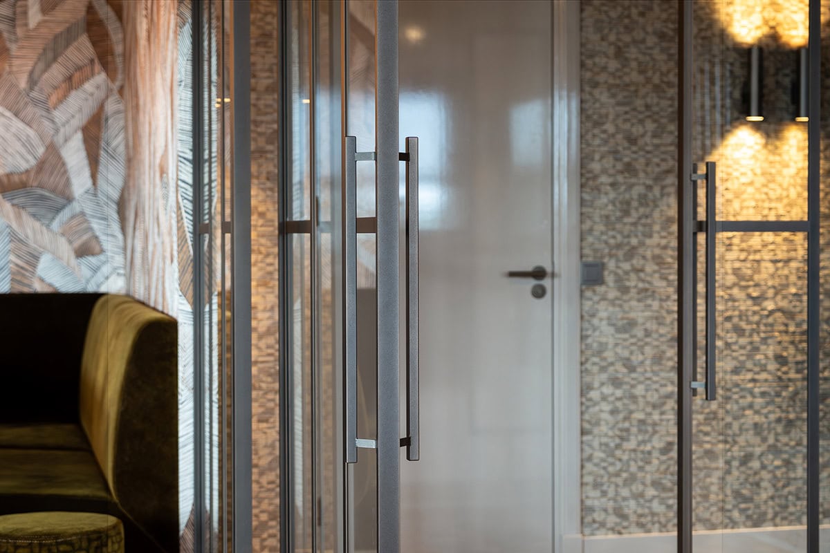 Strakke stalen deur met grote handgrepen en glazen panelen, perfect voor moderne interieur stijlen.