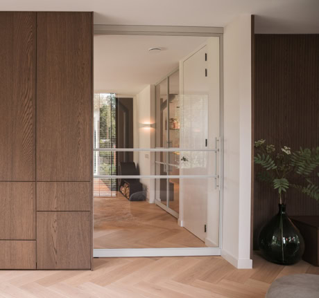 Modern steel sliding door with glass panels in a contemporary interior.