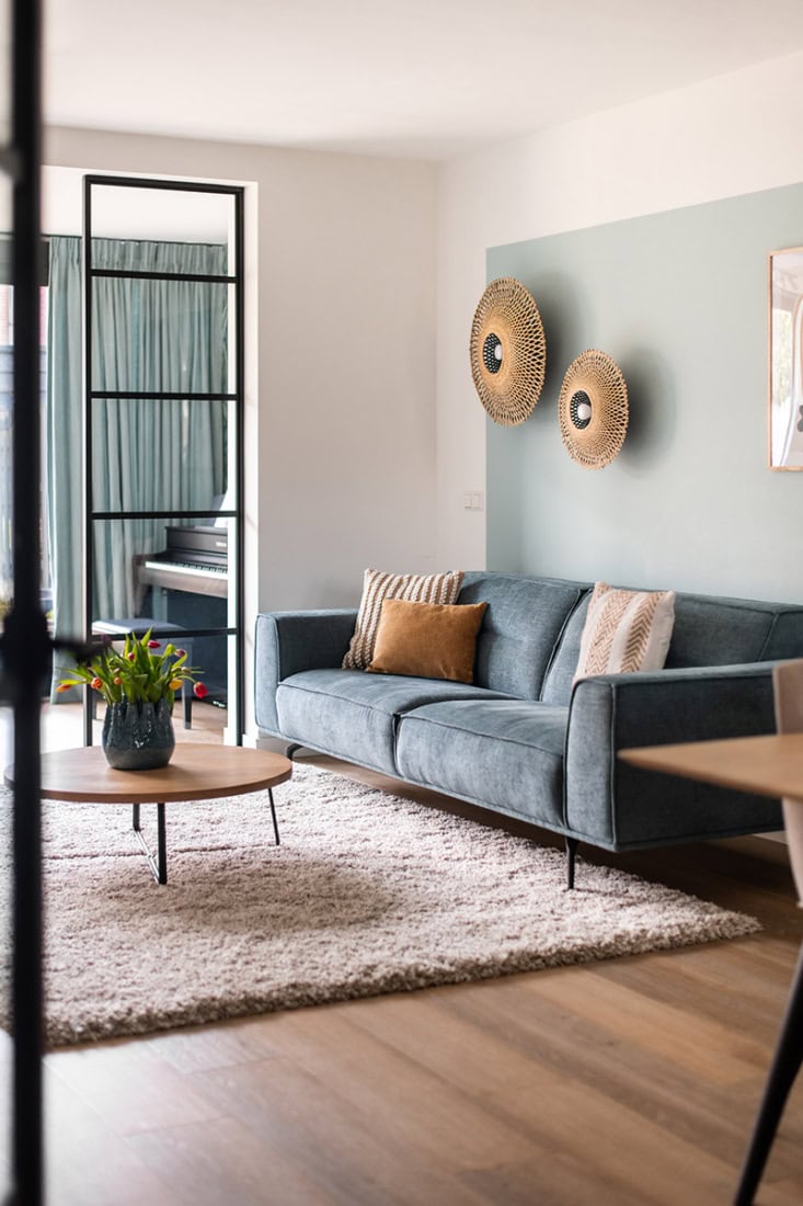 Modern living room with steel door and cosy seating area, matching bespoke steel walls and doors from Aluwdoors.