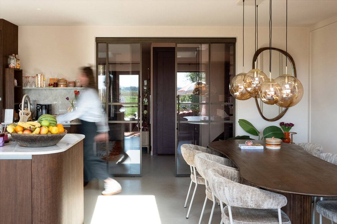 High-quality custom-made steel sliding doors and walls in a modern interior, combined with natural materials and atmospheric lighting.