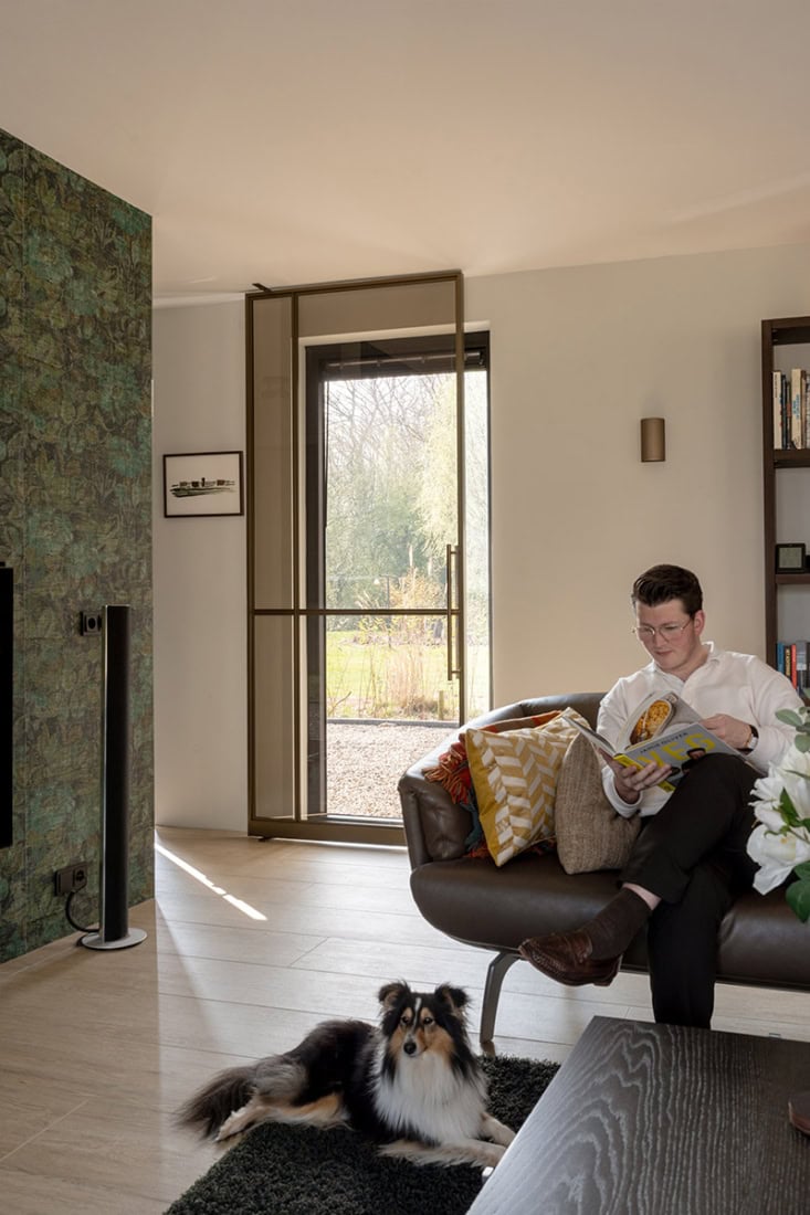 Led steel door with sliding mechanism, modern interior with natural light and stylish furnishings, house with custom-made steel doors and walls.