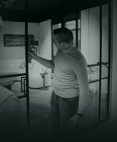 Steel door with black frame and glass panels in modern interior, man inspected for customisation and quality, perfect for stylish interior or exterior doors.