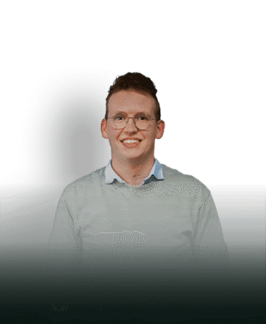 Modern man with glasses and jumper, smiling, on white background.