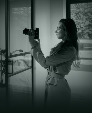 Elegant vrouw neemt foto van stalen deur in moderne interieuromgeving voor Aluwdoors.