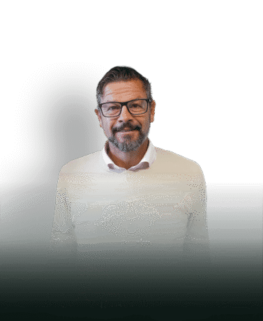 Elegant man in a white jumper with glasses, smiling and friendly, on a white background with shading, suitable for business or interior-related content.