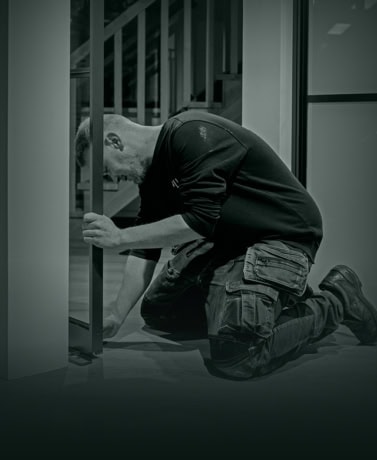 Precisie montage van stalen deuren op maat, ervaren monteur bevestigt deur tussen wand en frame voor een naadloze afwerking.