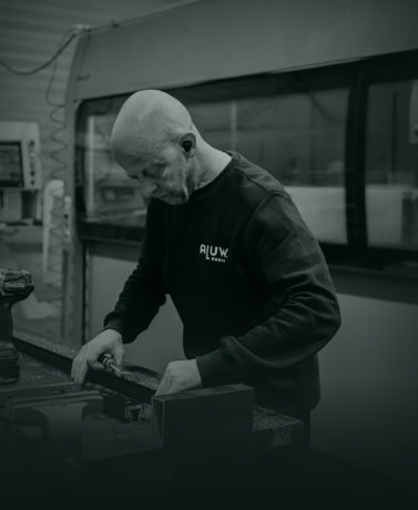 Strakke staaldeuren op maat wordt vakkundig vervaardigd door een professionele medewerker in een werkplaats.