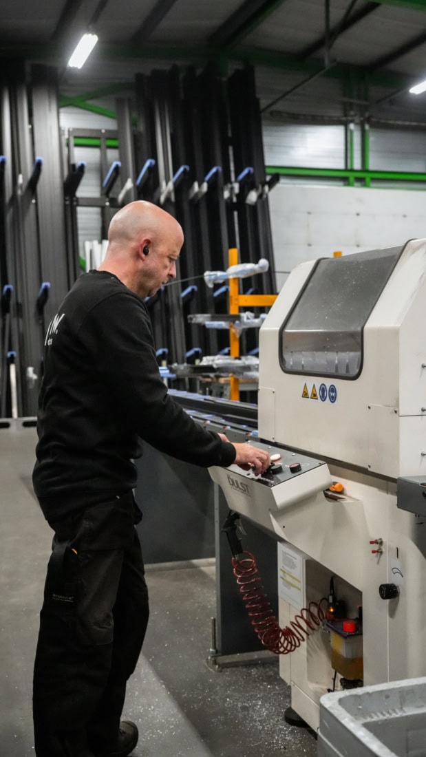 Productiemedewerker achter de snijmachine.