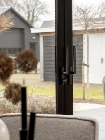 Modern aluminium external facade with black frames and double doors, installed in a house in Doornspijk, offers a sleek look and optimal light.