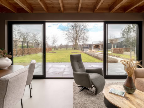 Spacious aluminium external facade with large glass panels, ideal for a modern house in Doornspijk, offers plenty of natural light and a beautiful view of the garden.