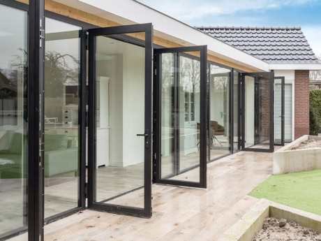 Aluminium buitenpui in Harderwijk met grote glazen deuren en zwarte frames, perfect voor een moderne en lichte uitstraling. Op maat gemaakte stalen deuren en wanden voor een stijlvolle buitenruimte.